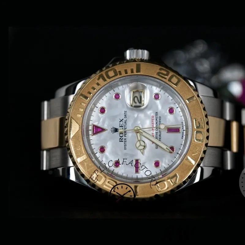 Studio view of Rolex Yacht-Master 16623 white MOP dial and gold bezel on bracelet, 40mm.