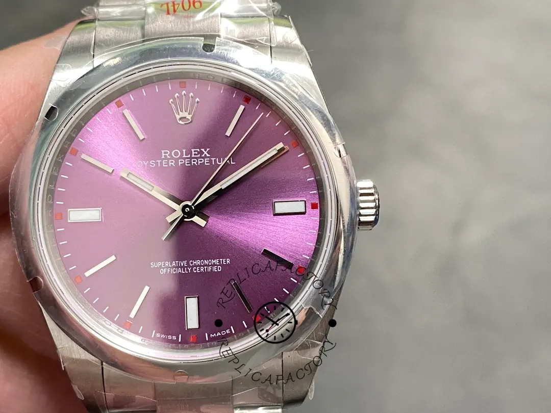 Handheld front view of the Rolex Oyster Perpetual 39 114300 0002 showing red grape dial.