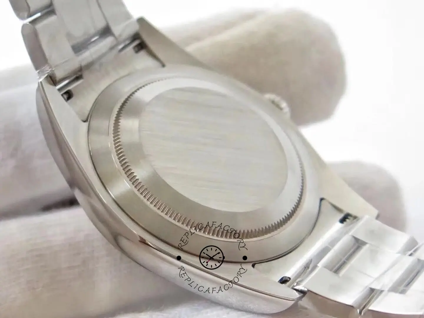 Caseback close-up of the Rolex Oyster Perpetual 114300 0001 showing solid back and end links.