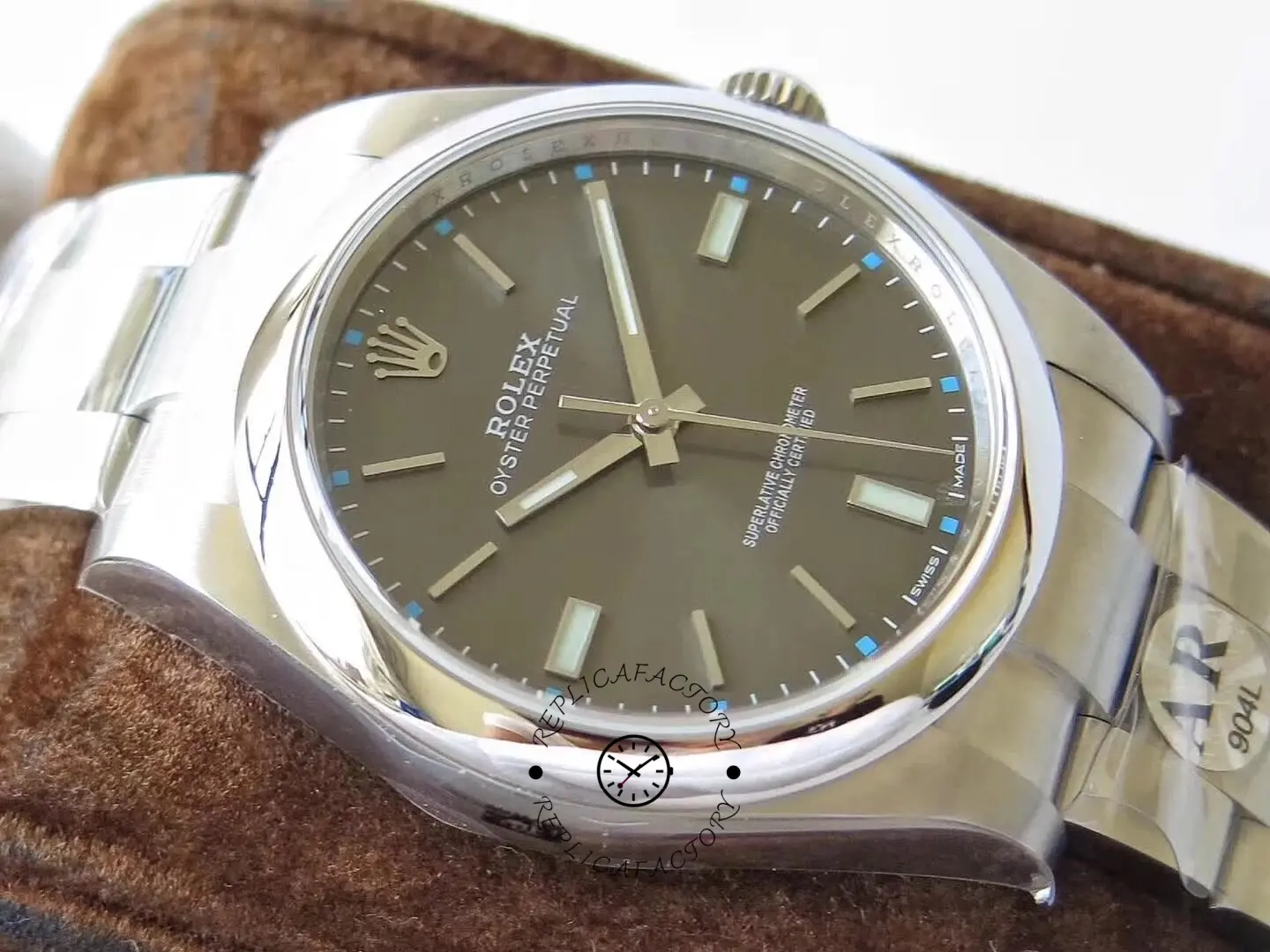 Angled close-up of the Rolex Oyster Perpetual 114300 0001 on leather stand showing case edge.