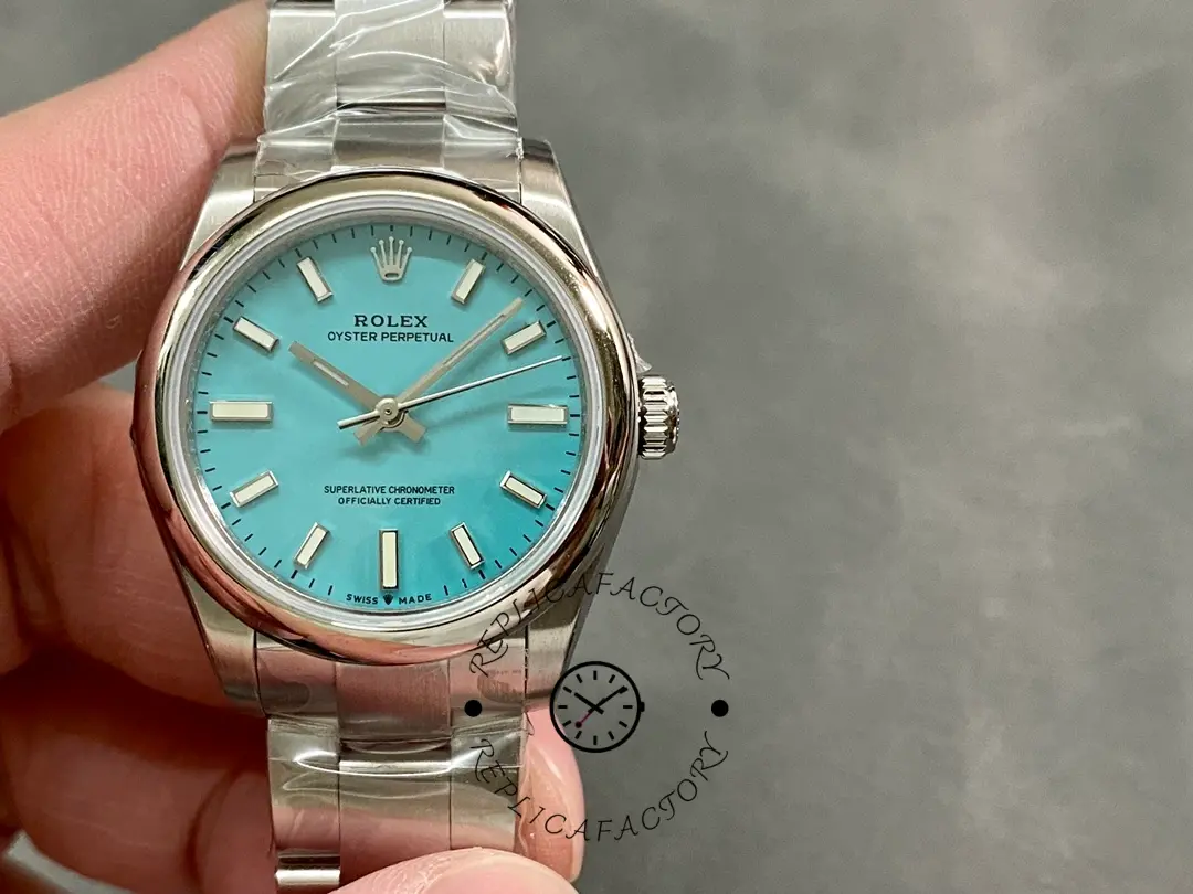 Rolex Oyster Perpetual 31 277200 0007, hand-held front view showing turquoise dial and markers.
