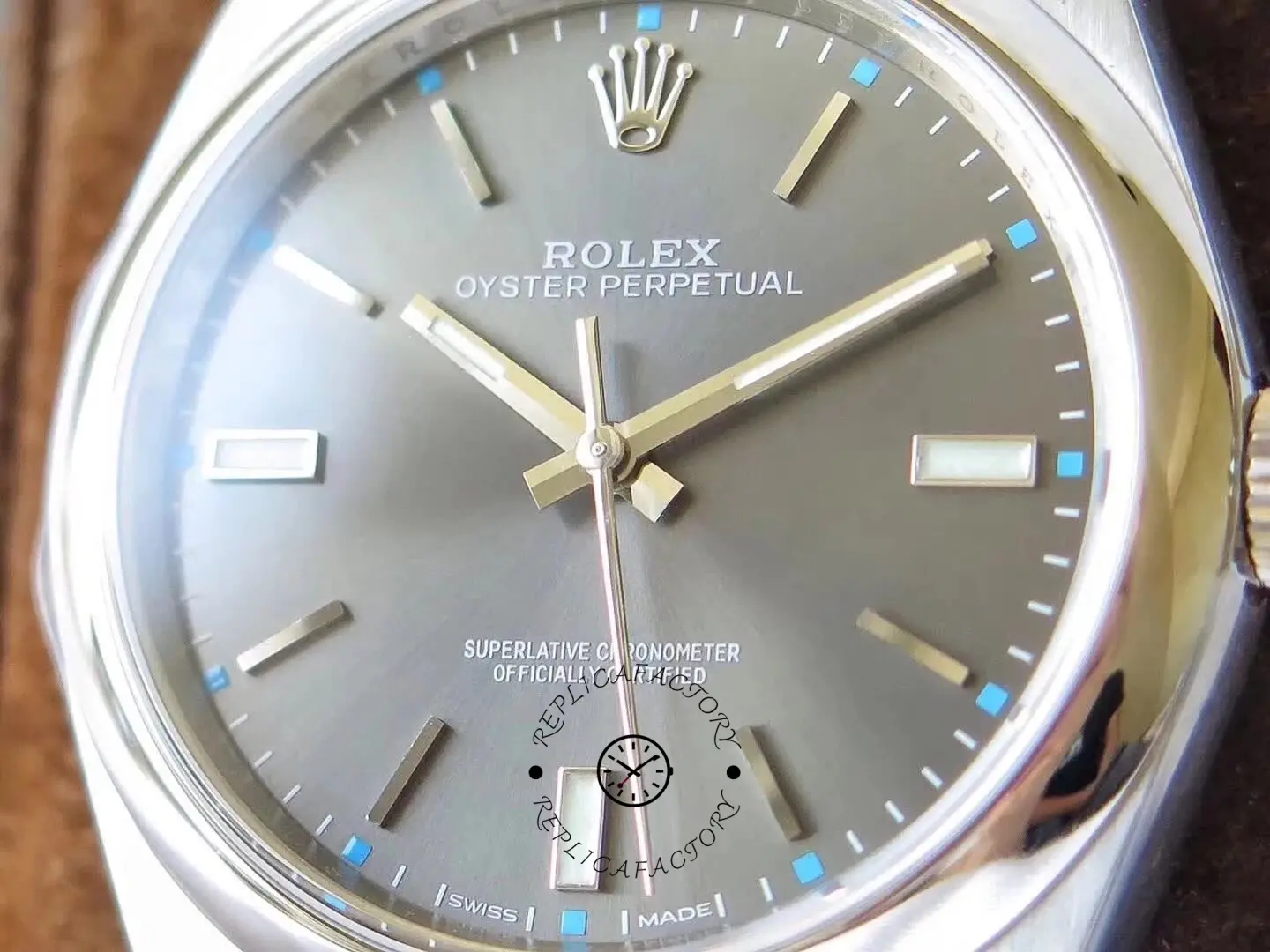 Dial close-up of the Rolex Oyster Perpetual 114300 0001 showing markers, hands, and text.