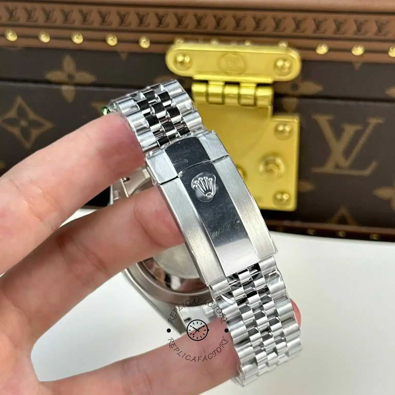 Bracelet side detail of Rolex Sky-Dweller m336934 0008 held in hand, showing Jubilee link texture.