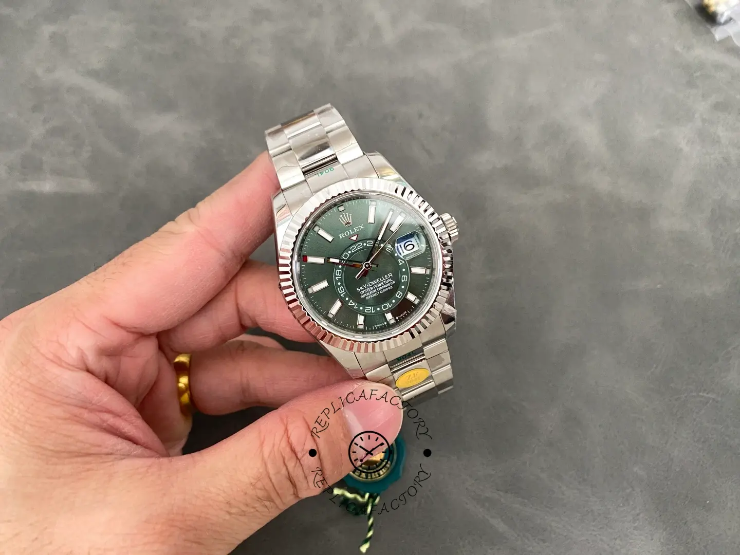 Hand holding Rolex Sky-Dweller 336934 showing full case and bracelet.