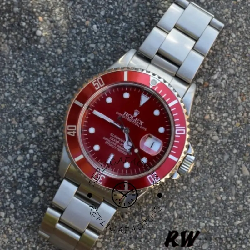 Rolex Submariner 16610, flat lay on textured surface showing red dial and oyster bracelet links.
