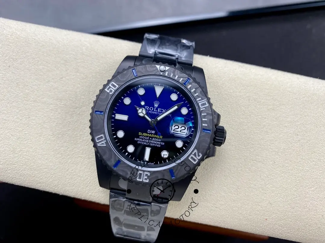 Top view of Rolex Submariner DIW 116610 on cushion showing blue dial, carbon bezel, and black strap.