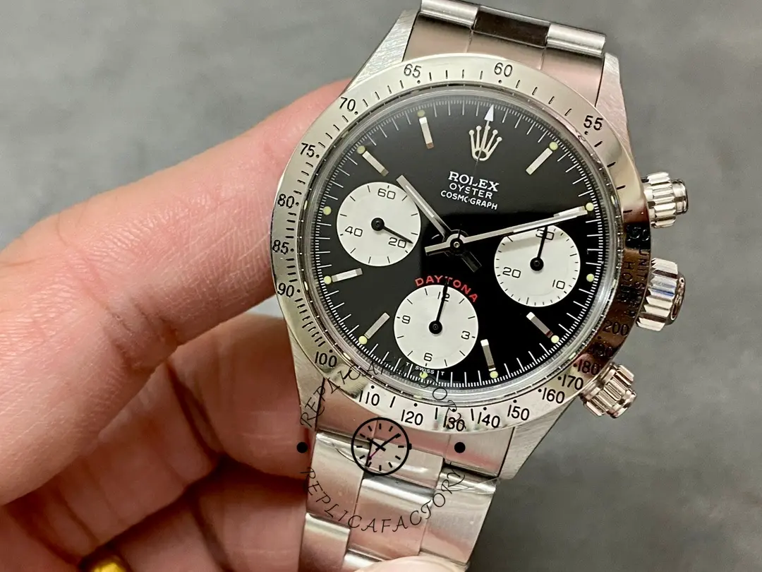 Rolex Daytona 6265, front view held in hand showing chronograph pushers and steel bracelet links.