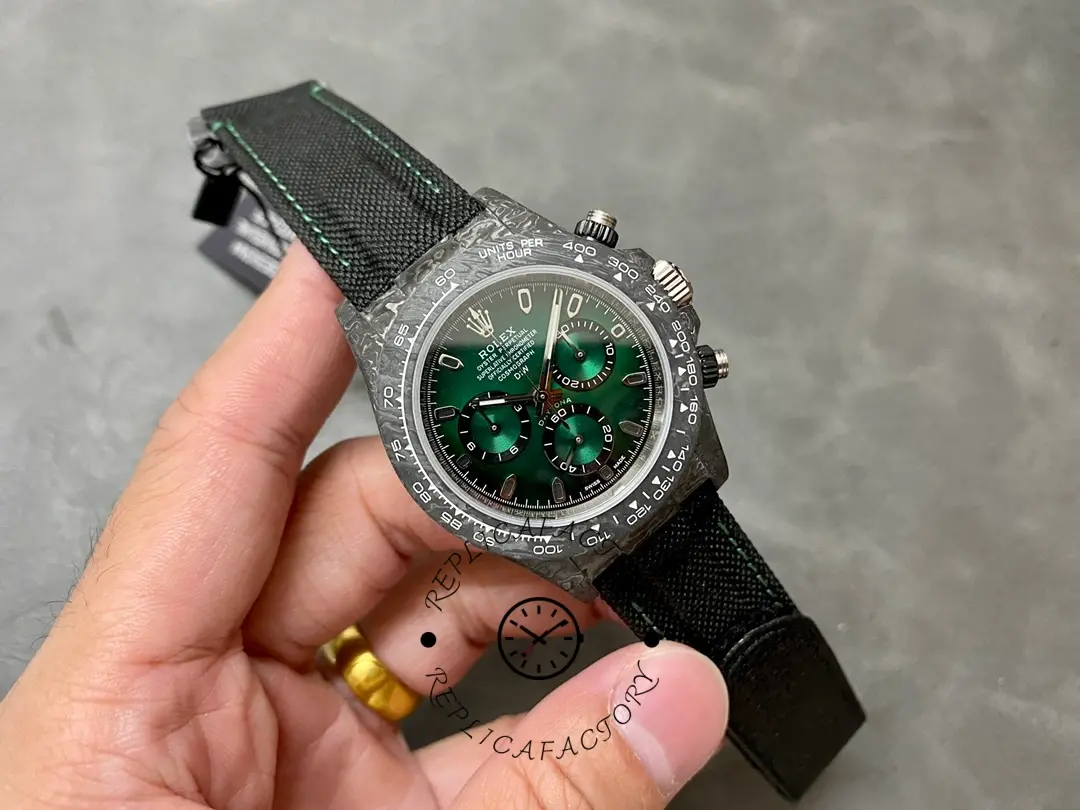 Rolex Daytona DIW 40mm, small-in-hand shot showing the black strap and compact case shape.