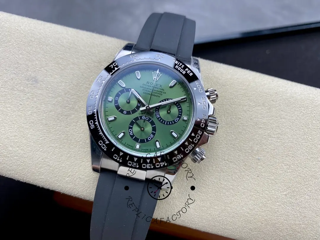 Rolex Daytona 126506, full watch on cushion showing green dial and black rubber strap.