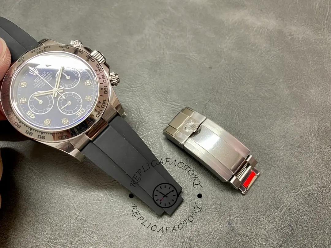 Rolex Daytona 116519 set on black strap with clasp piece beside it, showing accessories and finish.