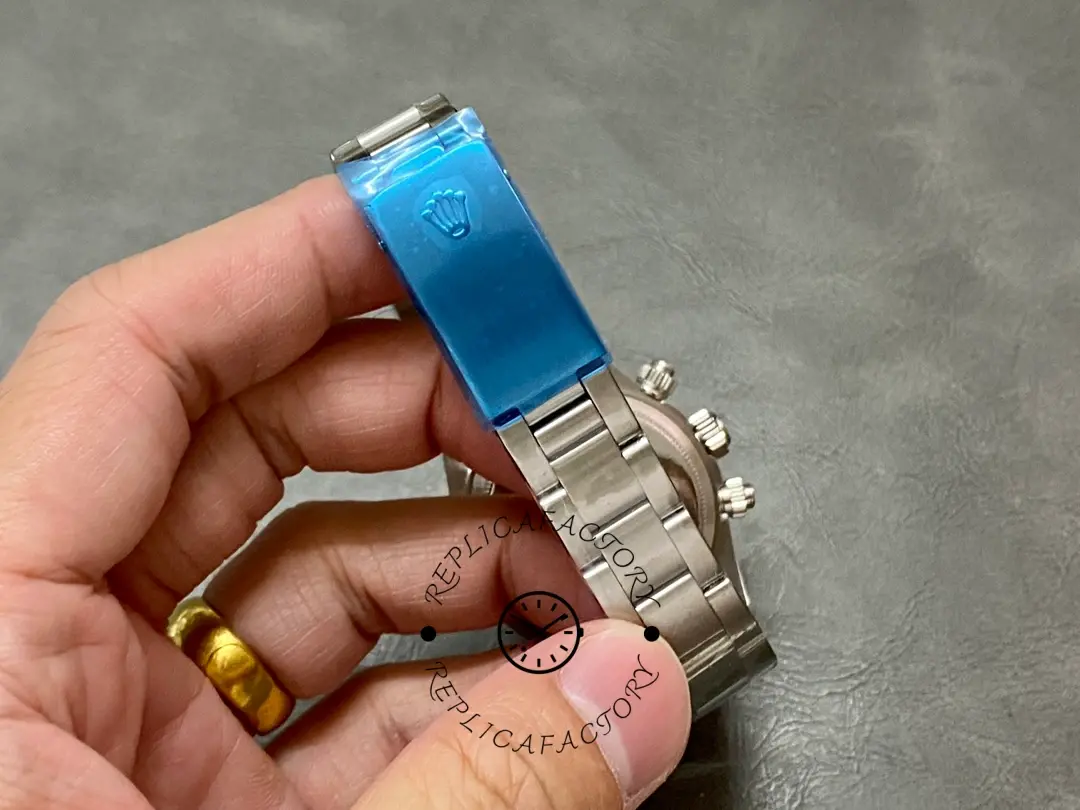Rolex Daytona 6265, bracelet clasp closed, with a blue protective film strip on the bracelet.