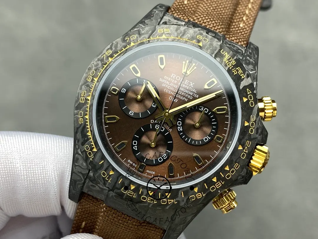 Front view in glove of Rolex Daytona DiW Black Gold, brown strap and gold chronograph pushers.