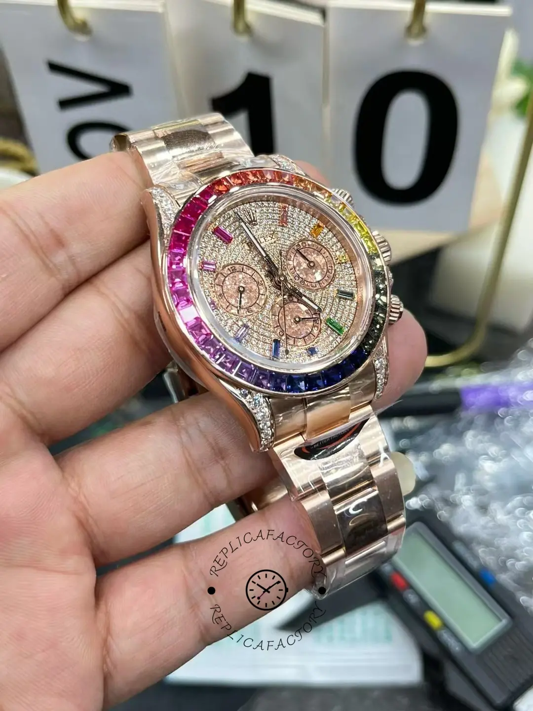 Rolex Daytona 116595RBOW angled view, rose gold case and rainbow sapphire bezel, pavé dial.