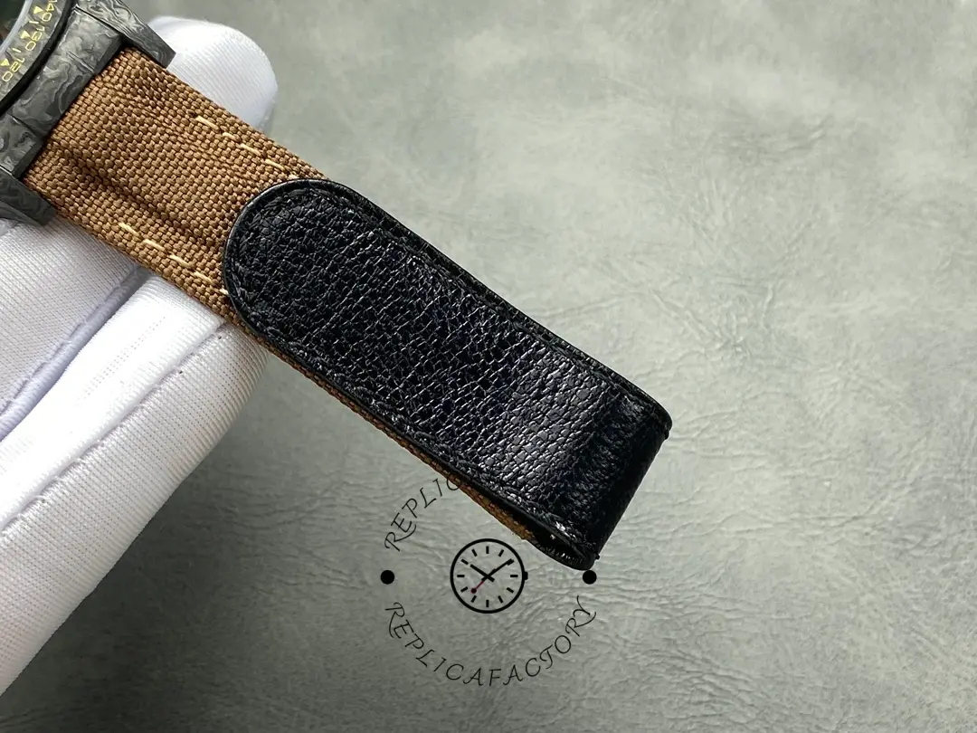 Strap tip detail of Rolex Daytona DiW Black Gold, brown strap with black keeper.