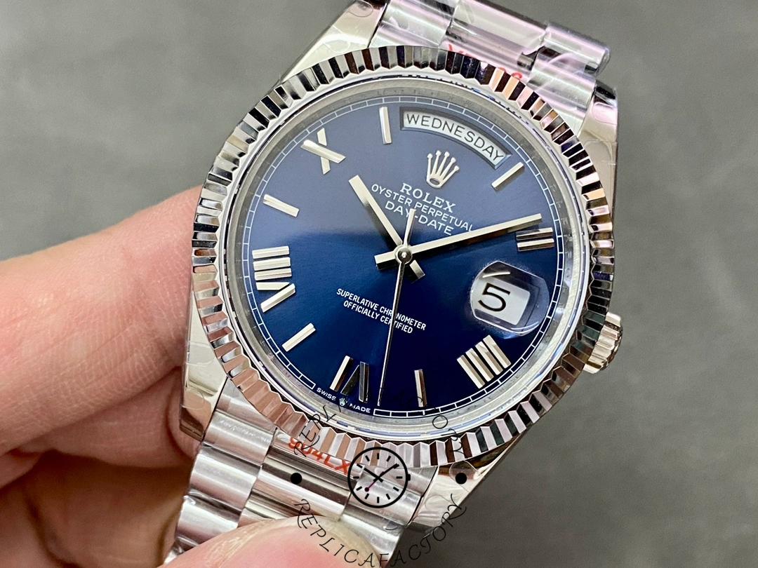 Tilted view of Rolex Day-Date 228239 in hand showing blue dial, fluted bezel and date window.