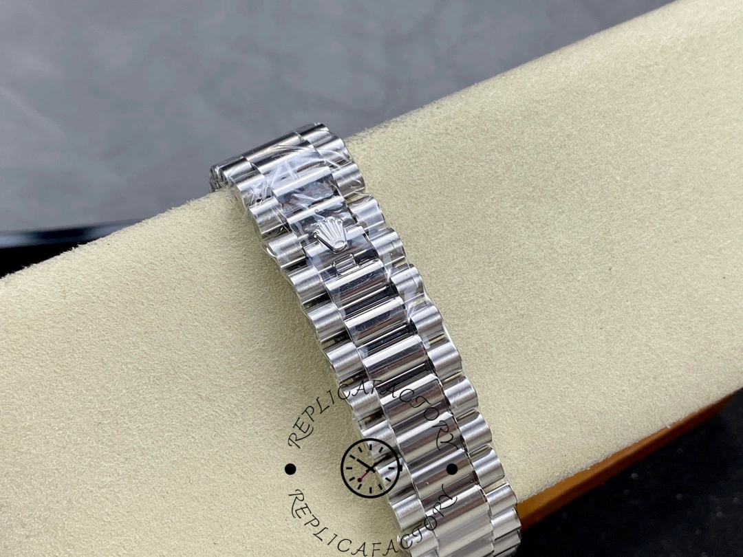 Rolex Day-Date 228239 bracelet close-up on cushion showing polished links and Rolex crown logo detail.