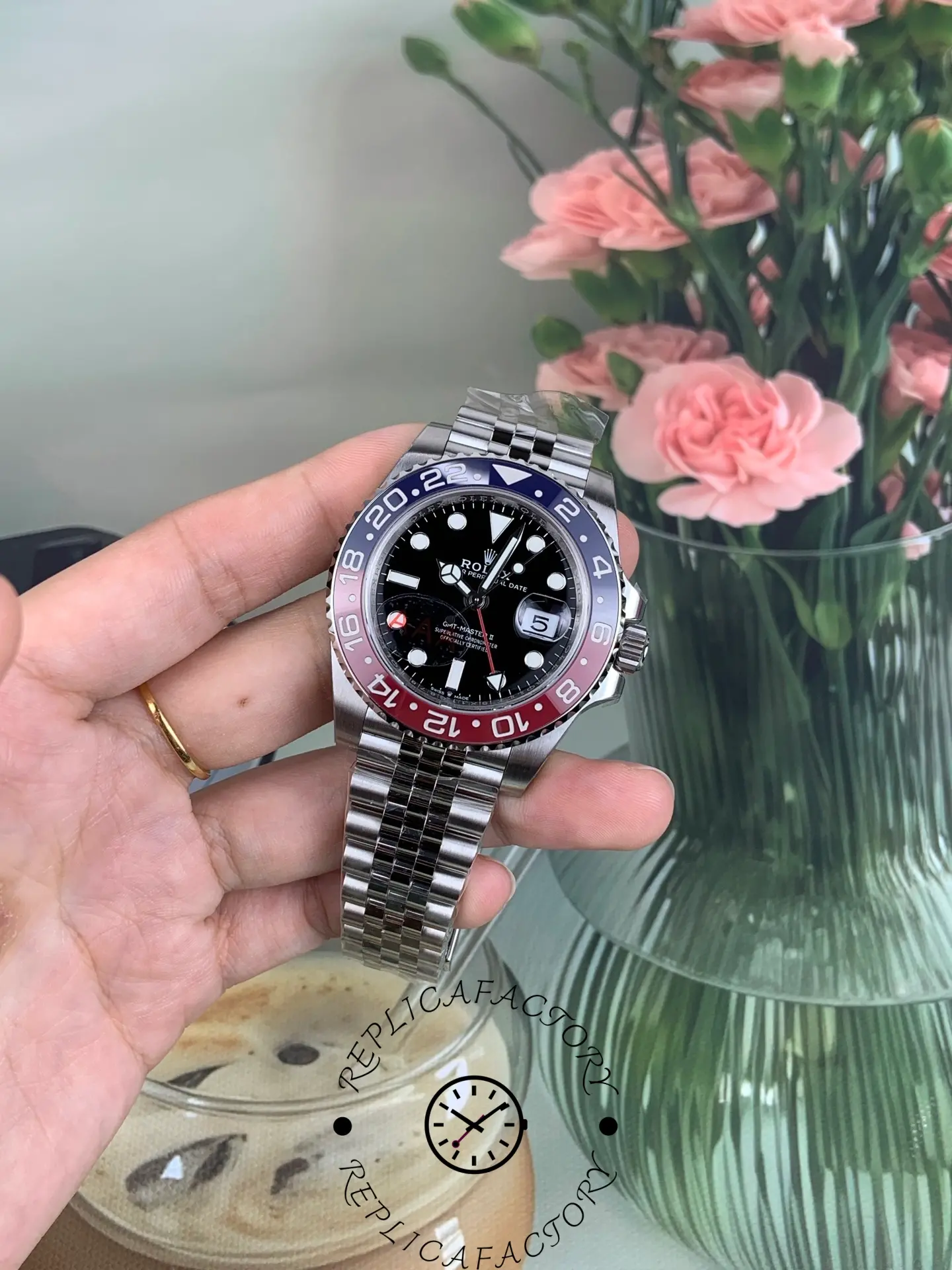 Rolex GMT-Master II 126710BLRO in hand with Jubilee bracelet, showing bezel and dial from left angle.