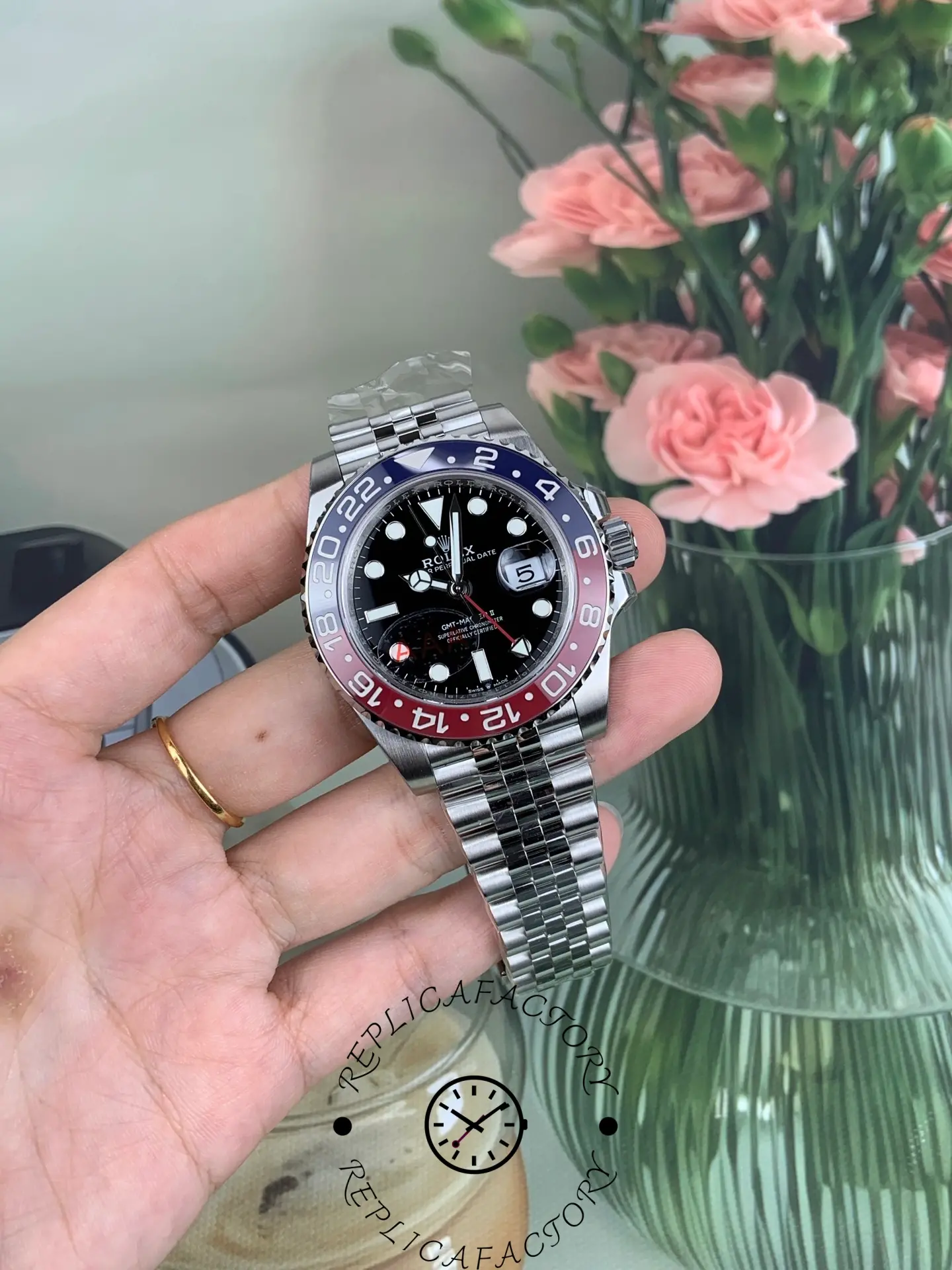 Rolex GMT-Master II 126710BLRO held in hand, Pepsi bezel and black dial, angled full view.