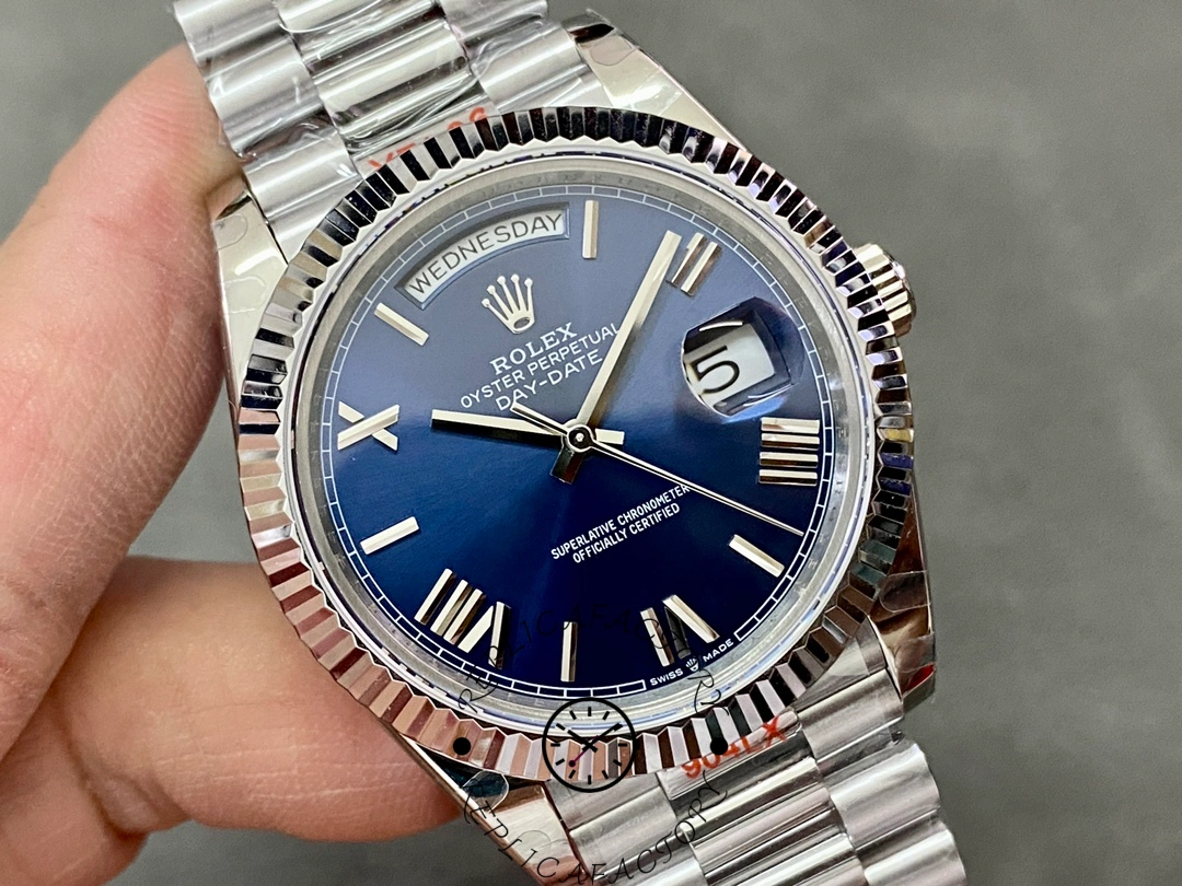 Angled close-up of Rolex Day-Date 228239 showing blue Roman dial, fluted bezel and cyclops date lens.