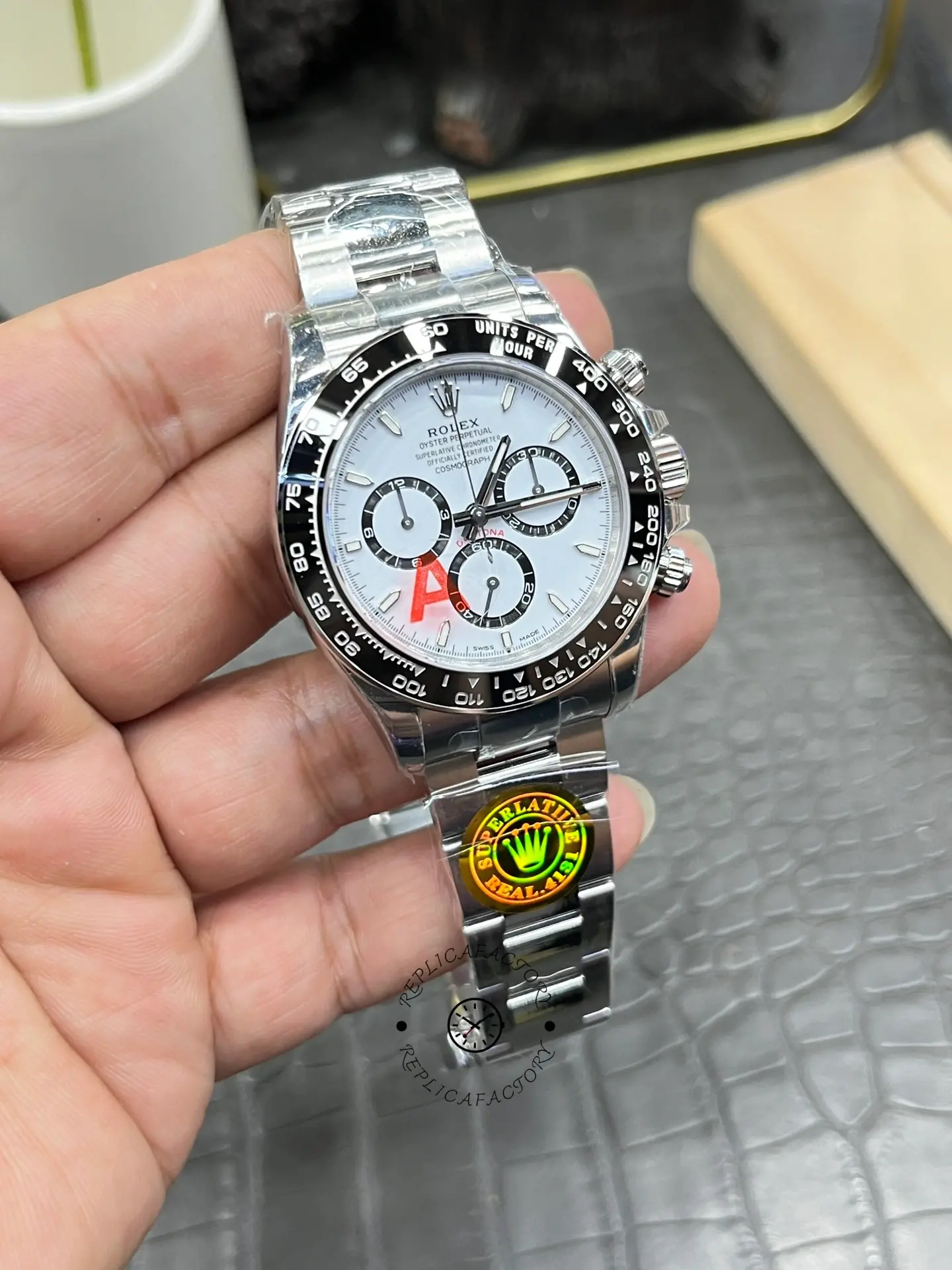 Rolex Daytona M126500LN-0001 handheld close-up, chronograph subdials and tachymeter scale.
