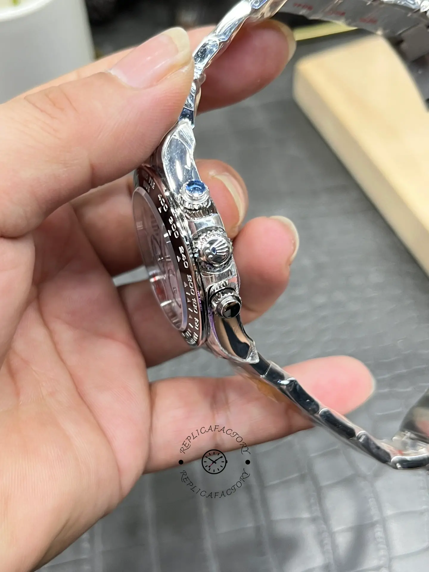 Rolex Daytona M126500LN-0001 bracelet and crown view in hand.