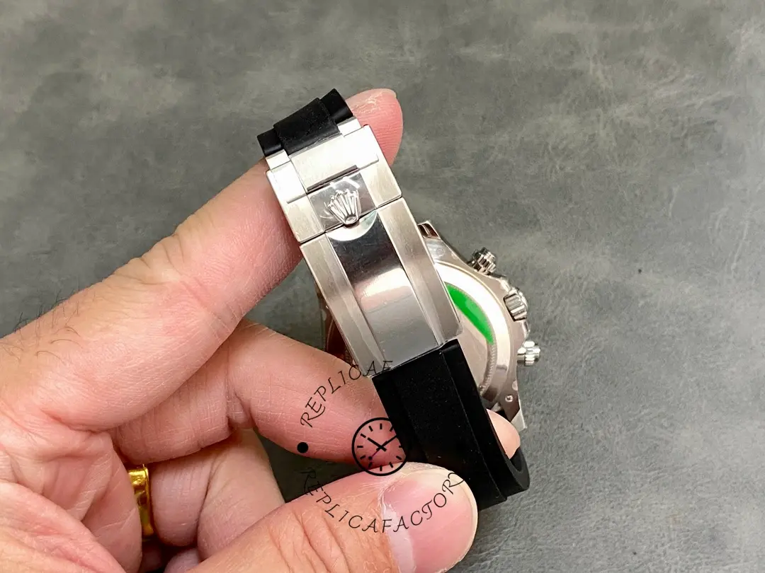 Clasp detail in hand of Rolex Daytona 116599 showing clasp edge and strap end.
