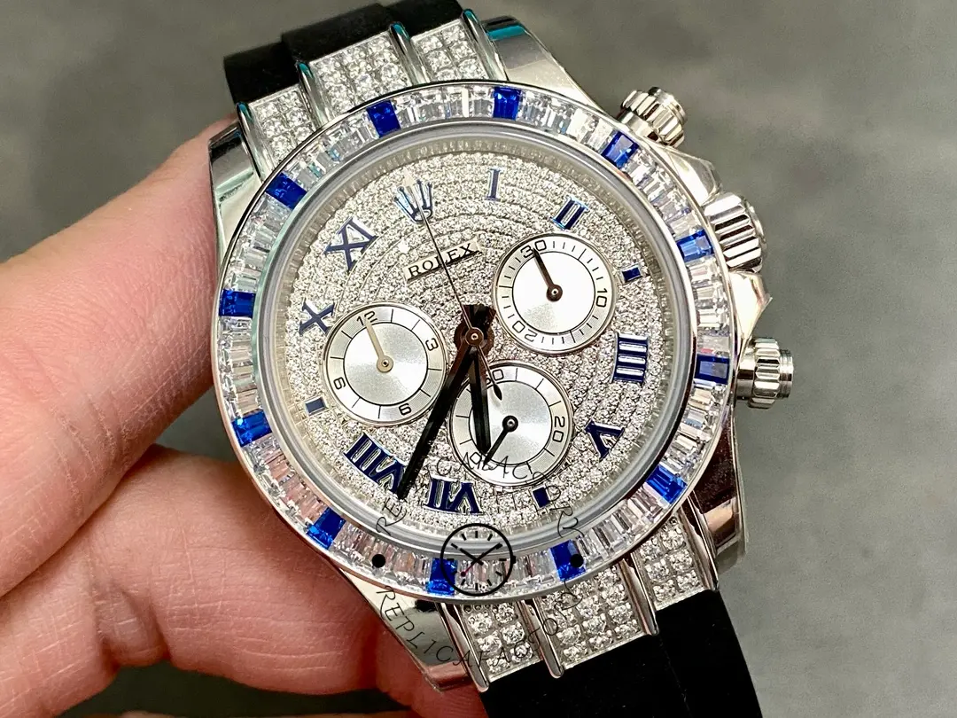 Hand-held close-up of Rolex Daytona 116599 highlighting blue Roman markers and subdials.