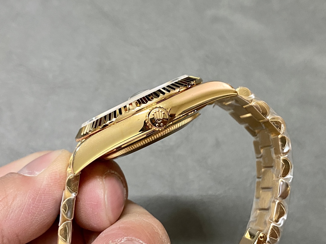 Side view of the Rolex Day-Date 228238 showing the fluted bezel and gold crown with engraved Rolex logo.