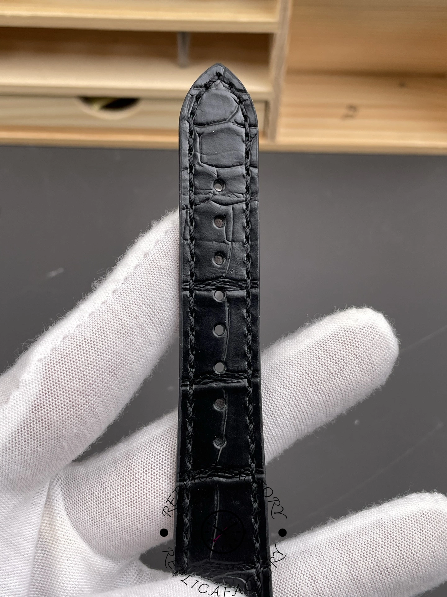 Close-up of Rolex 1908 52509 black leather strap with fine stitching.