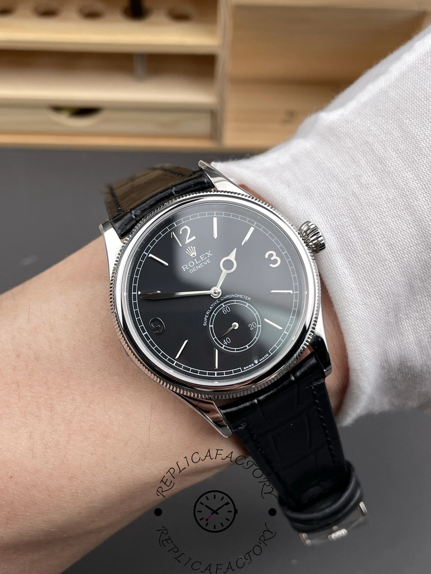 Wrist shot of Rolex 1908 52509 with black dial and glossy black leather strap.