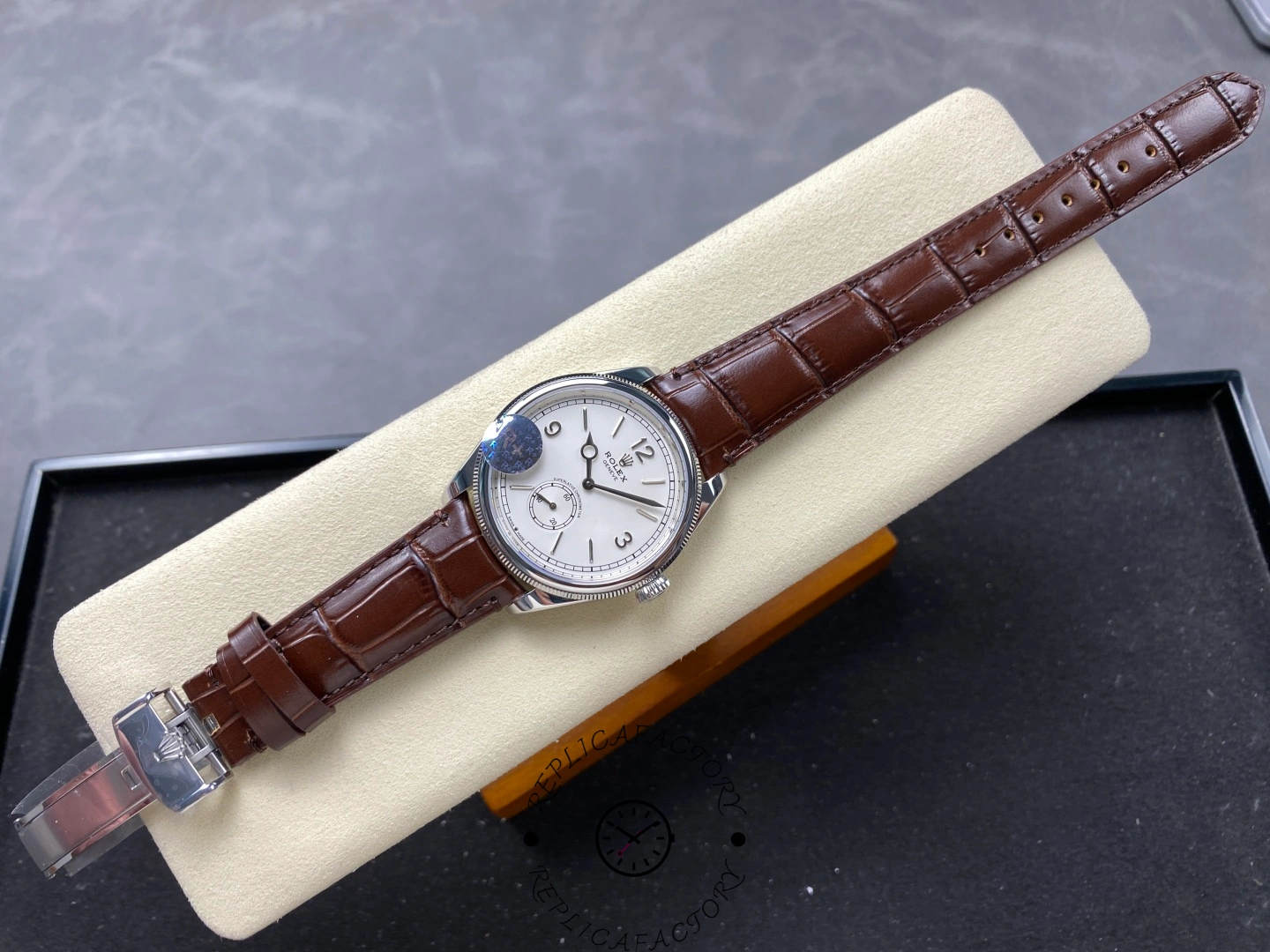 Full view of Rolex Perpetual 1908 52509-0006 laid flat showing brown leather strap and silver dial.