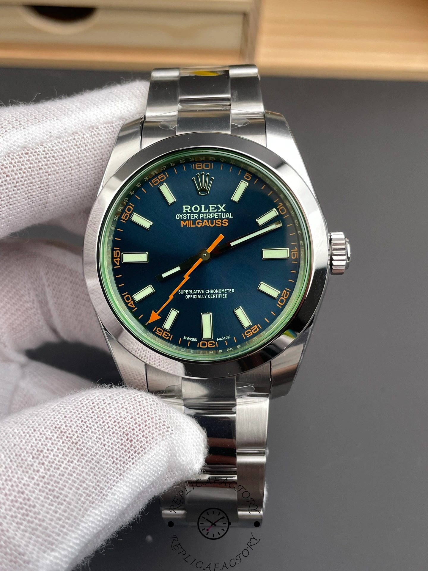 Close-up of Rolex Milgauss 116400GV showing green sapphire crystal and orange accents.