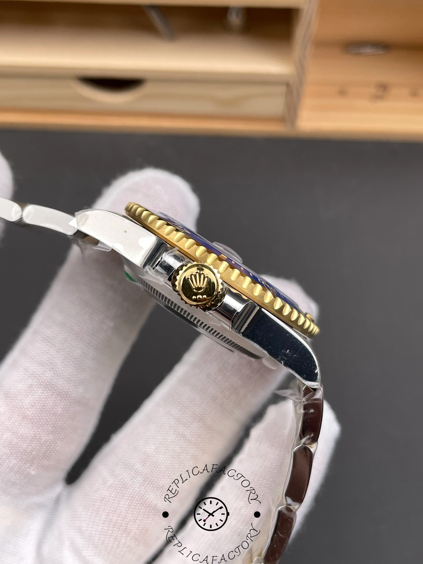 Side profile of the Rolex Submariner 116613LB showing the gold screw-down crown with Rolex logo.