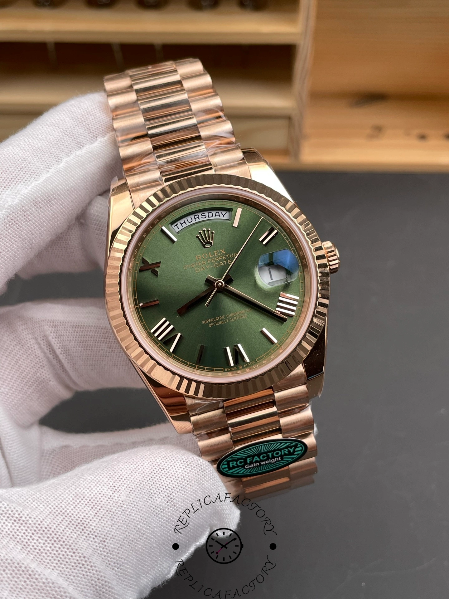 Angled front view of the Rolex Day-Date 40 Everose gold showing the green dial and Roman numeral hour markers.