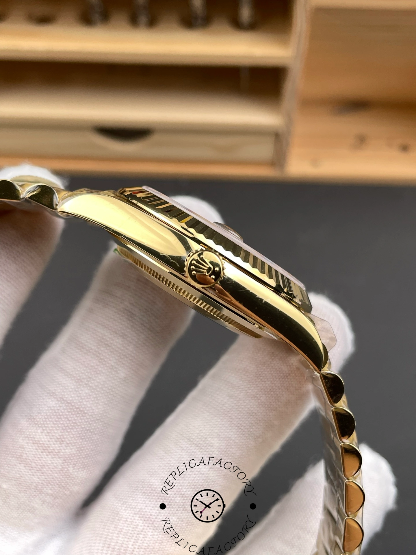 Side profile of the Rolex Day-Date 228238 showing the gold crown engraved with Rolex logo.