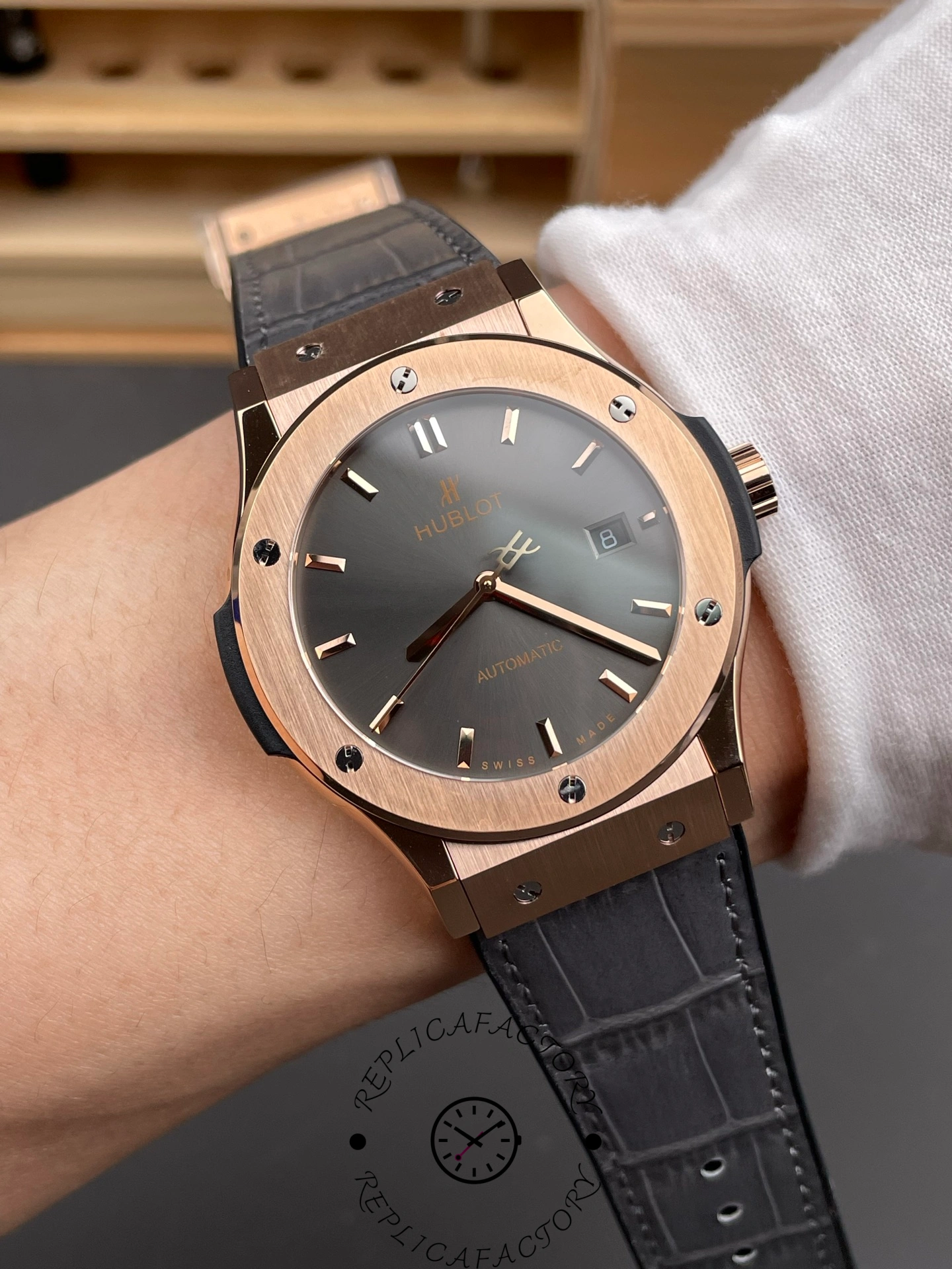 Wrist shot of Hublot Classic Fusion 511.OX.7081.LR replica showing elegant King Gold and grey dial contrast.