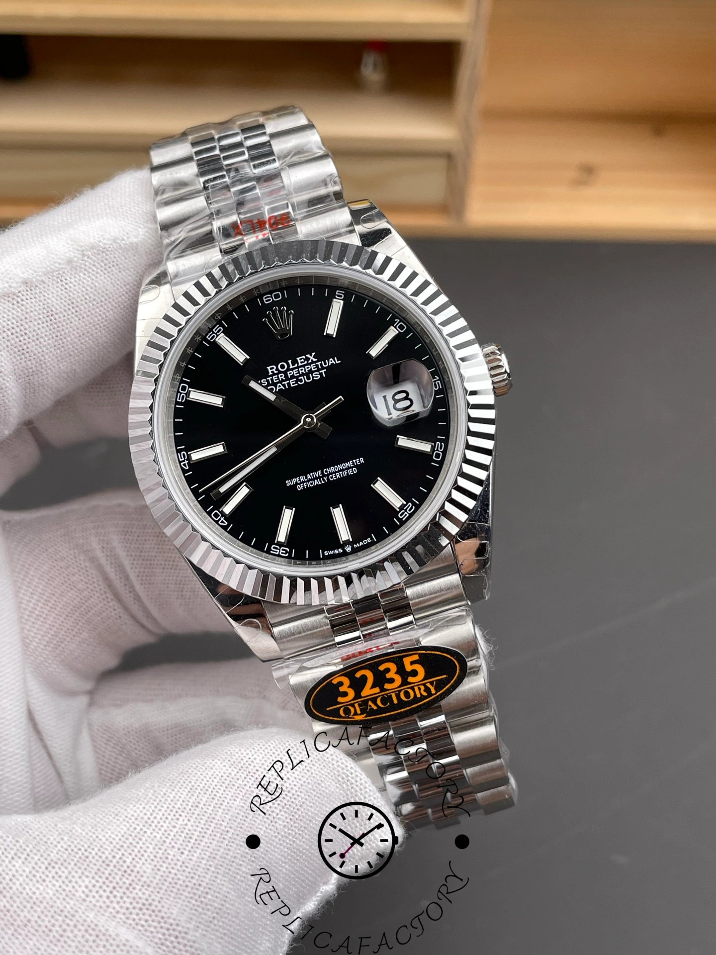 Front view of the Rolex Datejust 41mm 126334-0018 with black dial, fluted bezel, and Jubilee bracelet held by gloved hand.