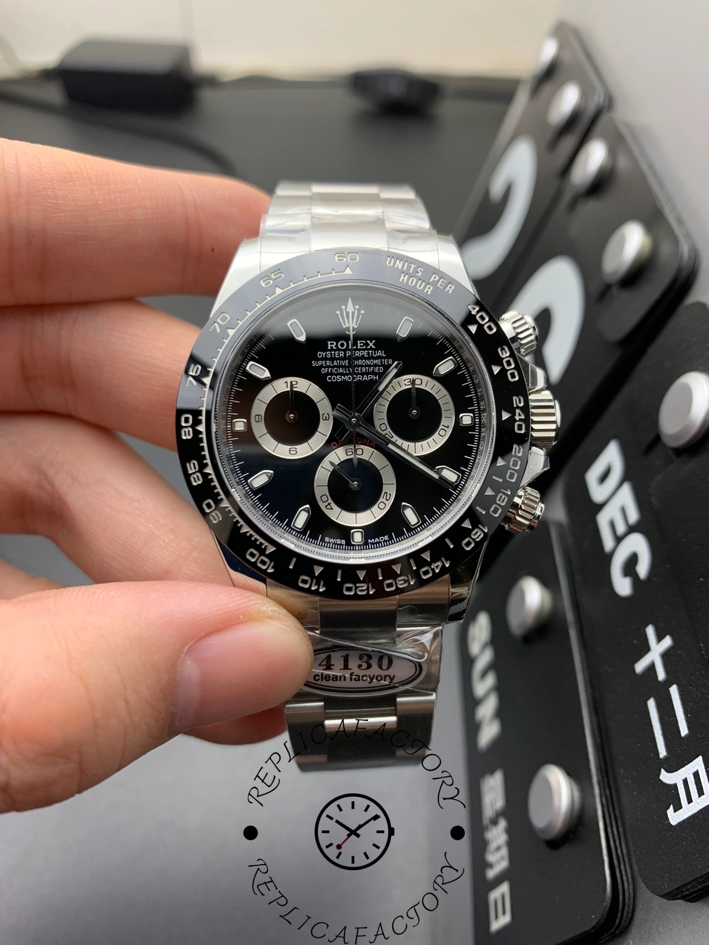 Front view of the Rolex Cosmograph Daytona m126500ln-0002 with black dial and ceramic bezel, showing chronograph subdials and “4130 Clean Factory” tag.