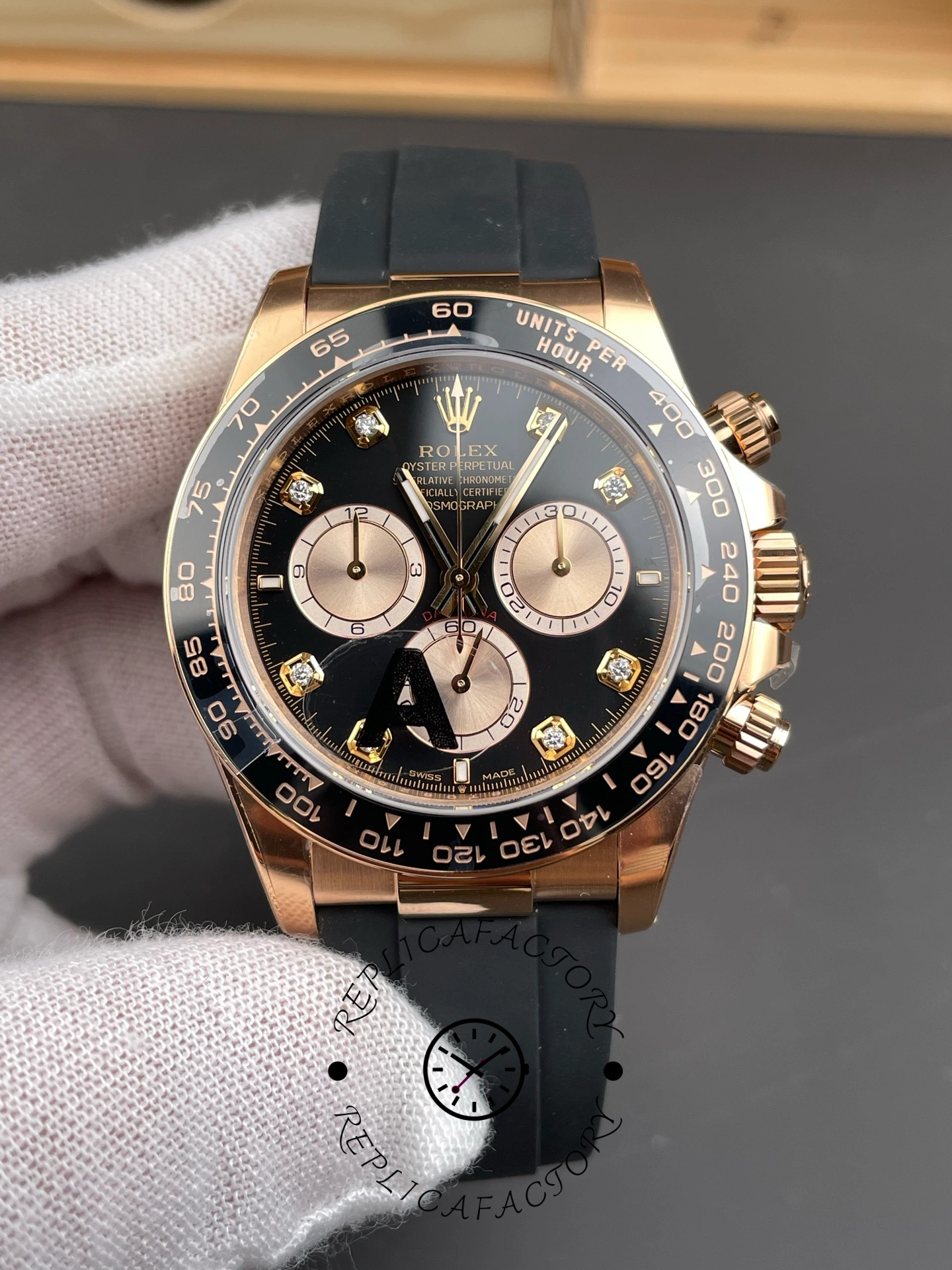 Macro detail of ReplicaFactory Rolex Daytona 126515LN-0004 showing black dial and Everose gold pushers.