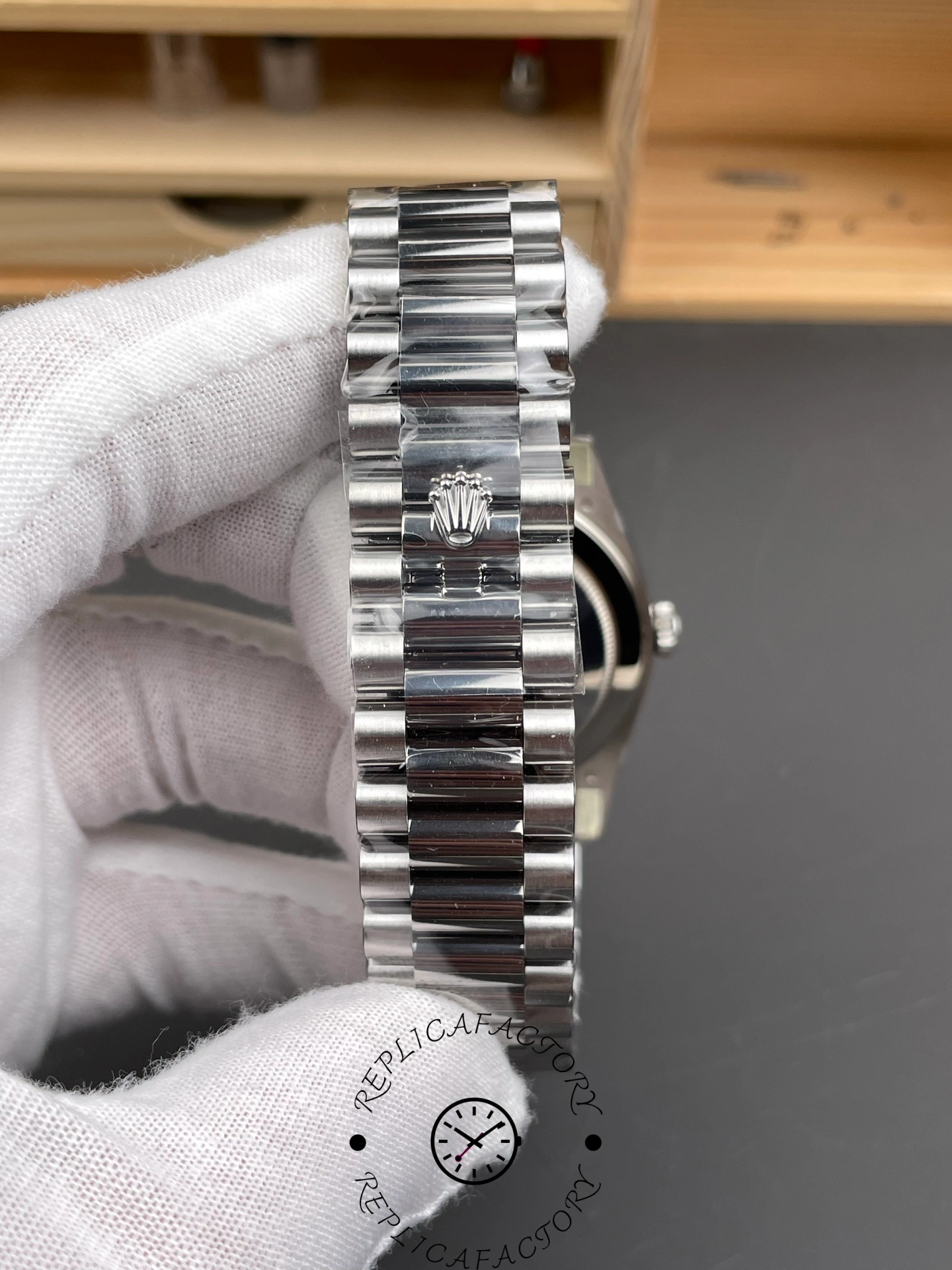 Bracelet close-up of RC Factory Rolex Day-Date 228239 showing polished and brushed links with Rolex clasp.