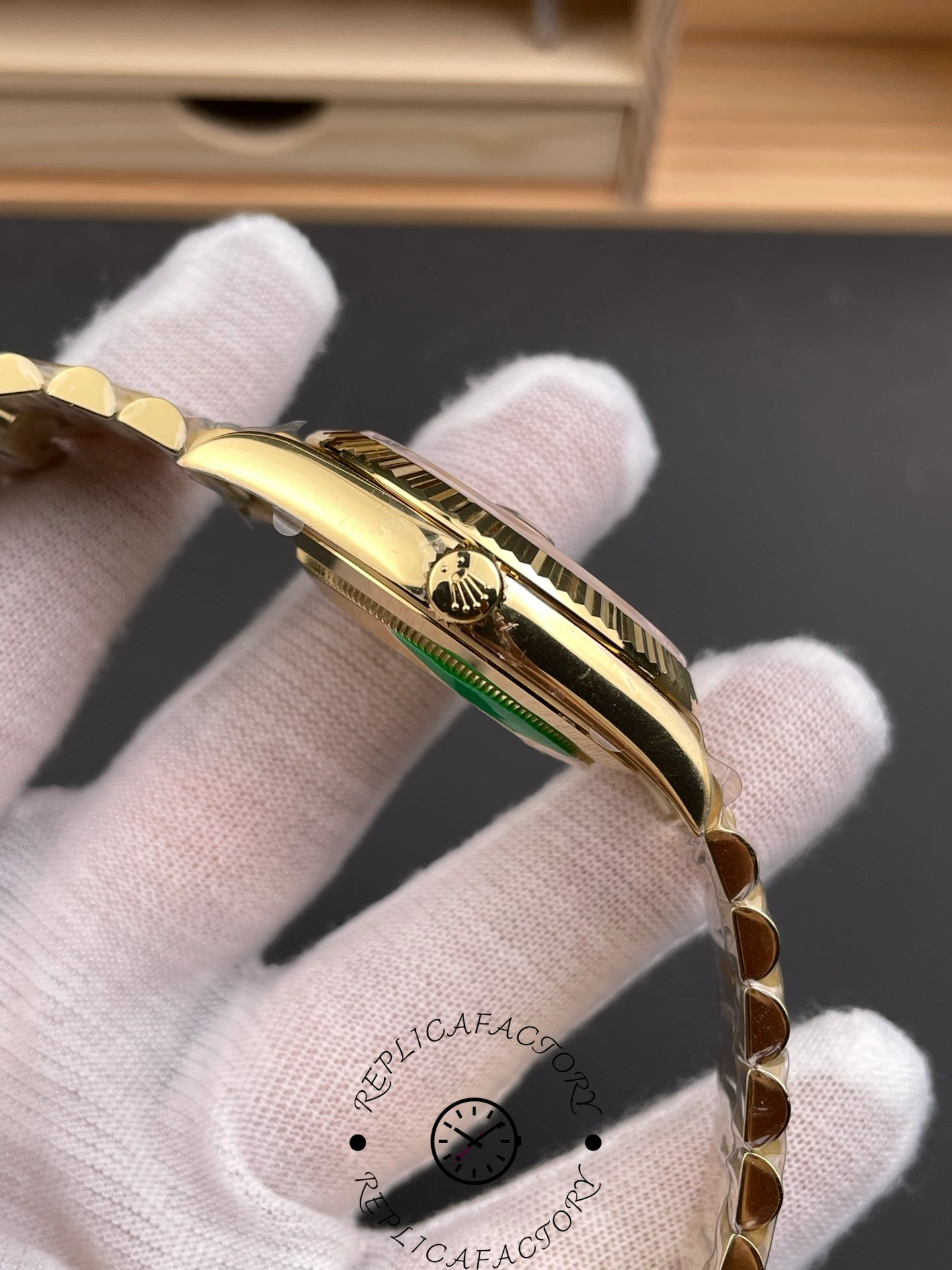 Side view of Rolex Day-Date 228238 showing the gold crown engraved with the Rolex logo.