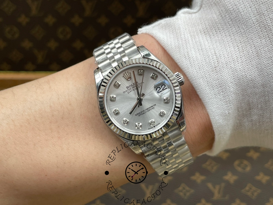 Wrist shot of ReplicaFactory Rolex Datejust m278274-0030 showing silver diamond dial on wrist under indoor light.