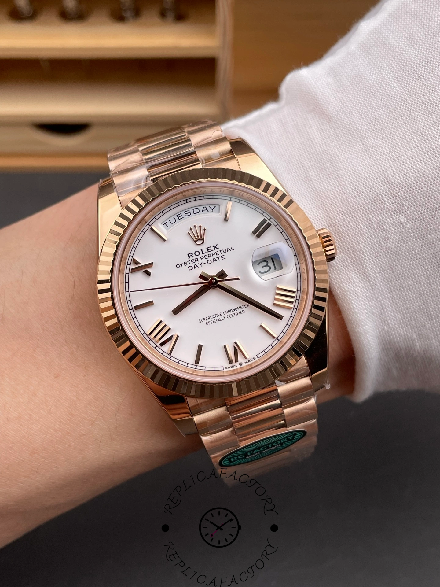 Wrist shot of Rolex Day-Date 228235 showing white Roman dial and fluted bezel on wrist.