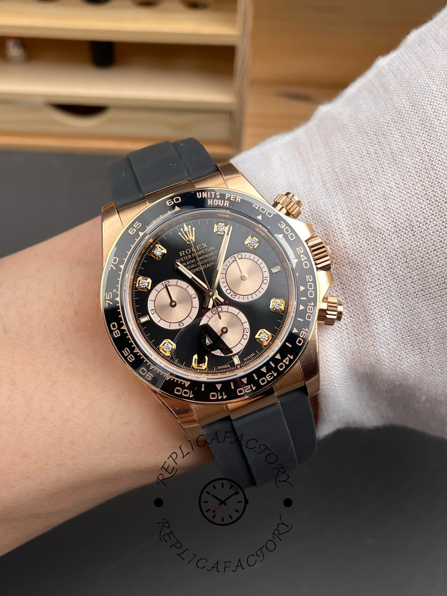 Wrist shot of ReplicaFactory Rolex Daytona 126515LN-0004 showing black dial with diamond hour markers under natural light.