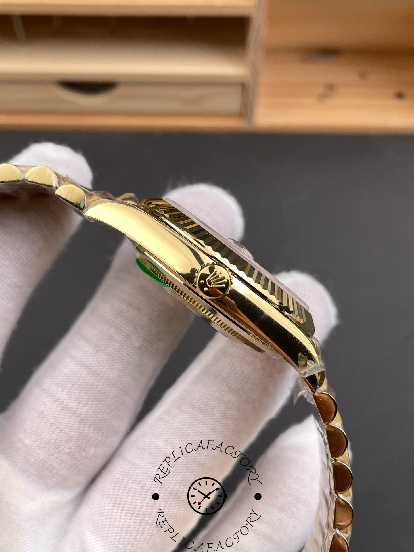 Side view of RC Factory Rolex Day-Date 228238 showing yellow gold crown and polished case.