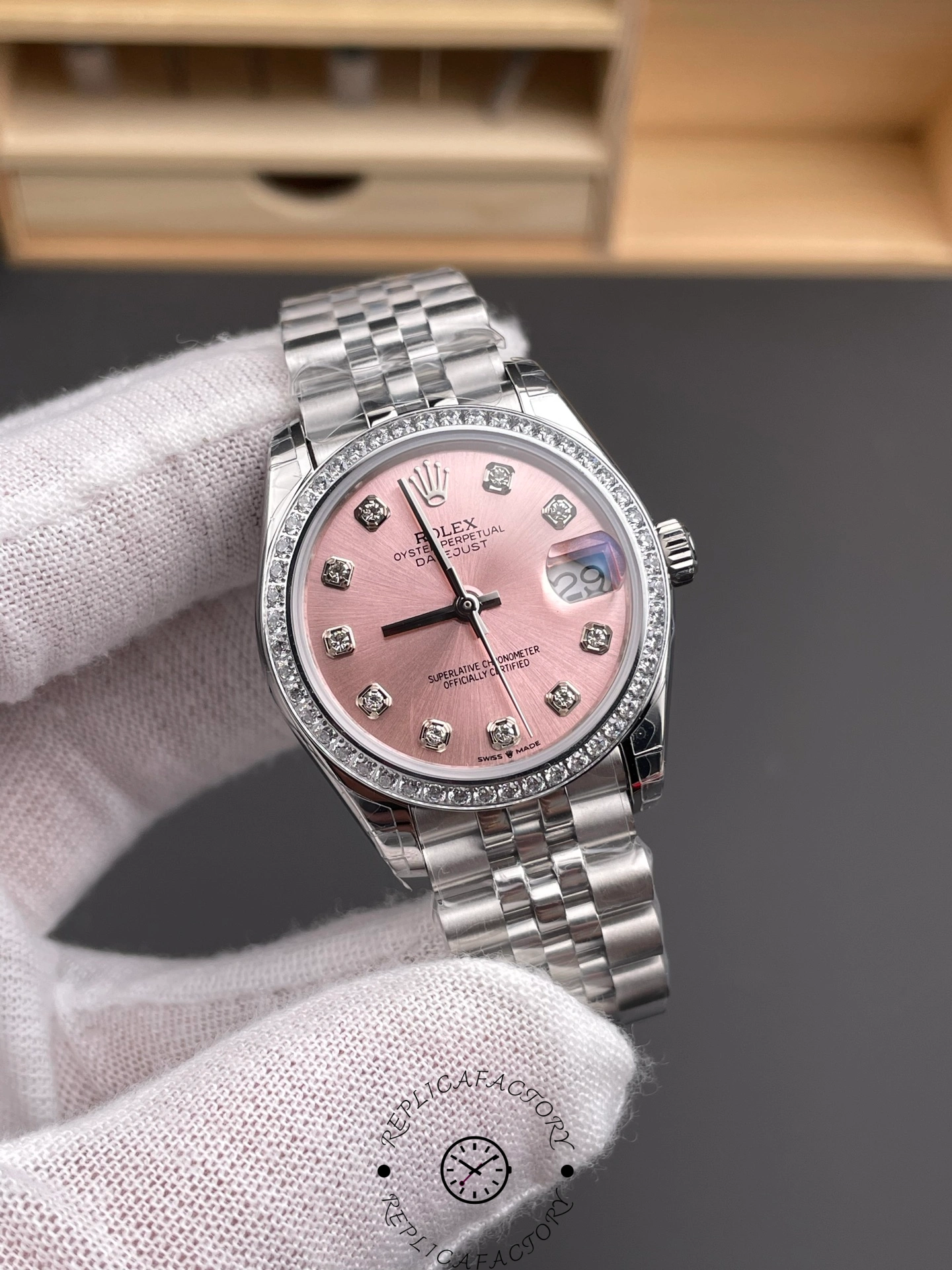 Angled view of Rolex Datejust 31 m278384rbr 0036 pink dial with diamond bezel and steel case.