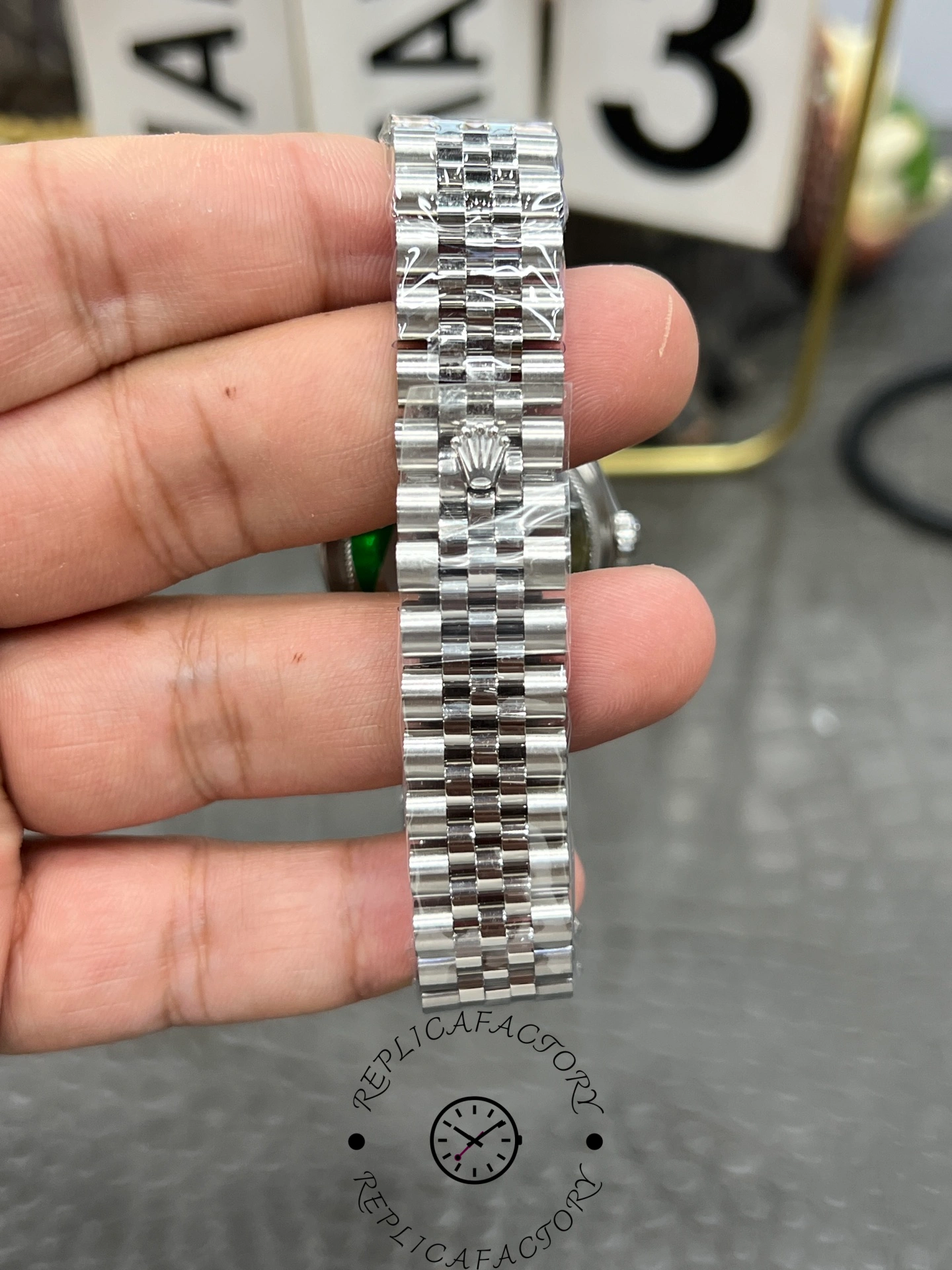 Bracelet clasp exterior of ReplicaFactory Rolex Datejust 31mm 278274-0026 showing Rolex crown logo on polished clasp.