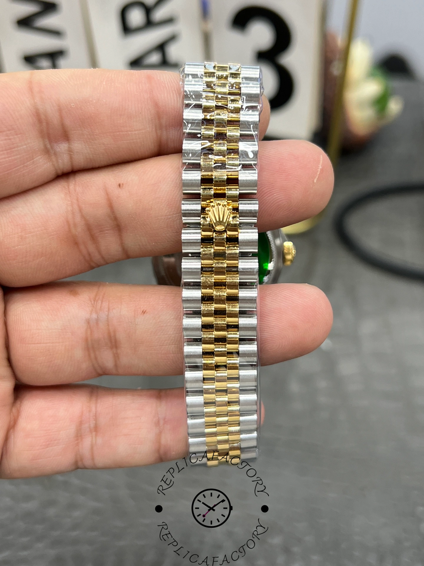 Bracelet clasp exterior of ReplicaFactory Rolex Datejust 31mm 278273-0030 showing Rolex crown on two-tone Jubilee bracelet.