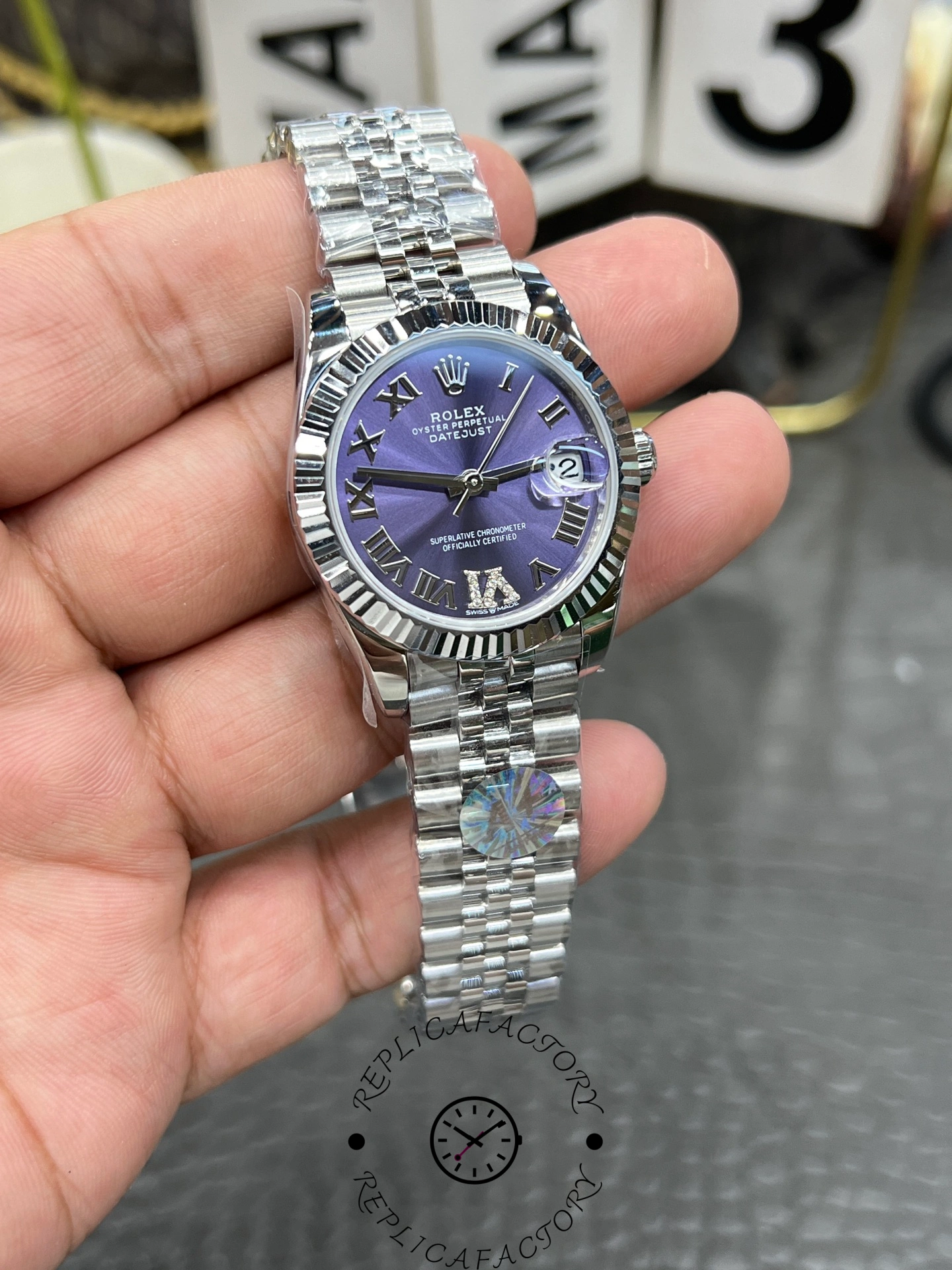 Close-up of ReplicaFactory Rolex Datejust 31mm 278274-0026 showing purple sunburst dial texture and date window.