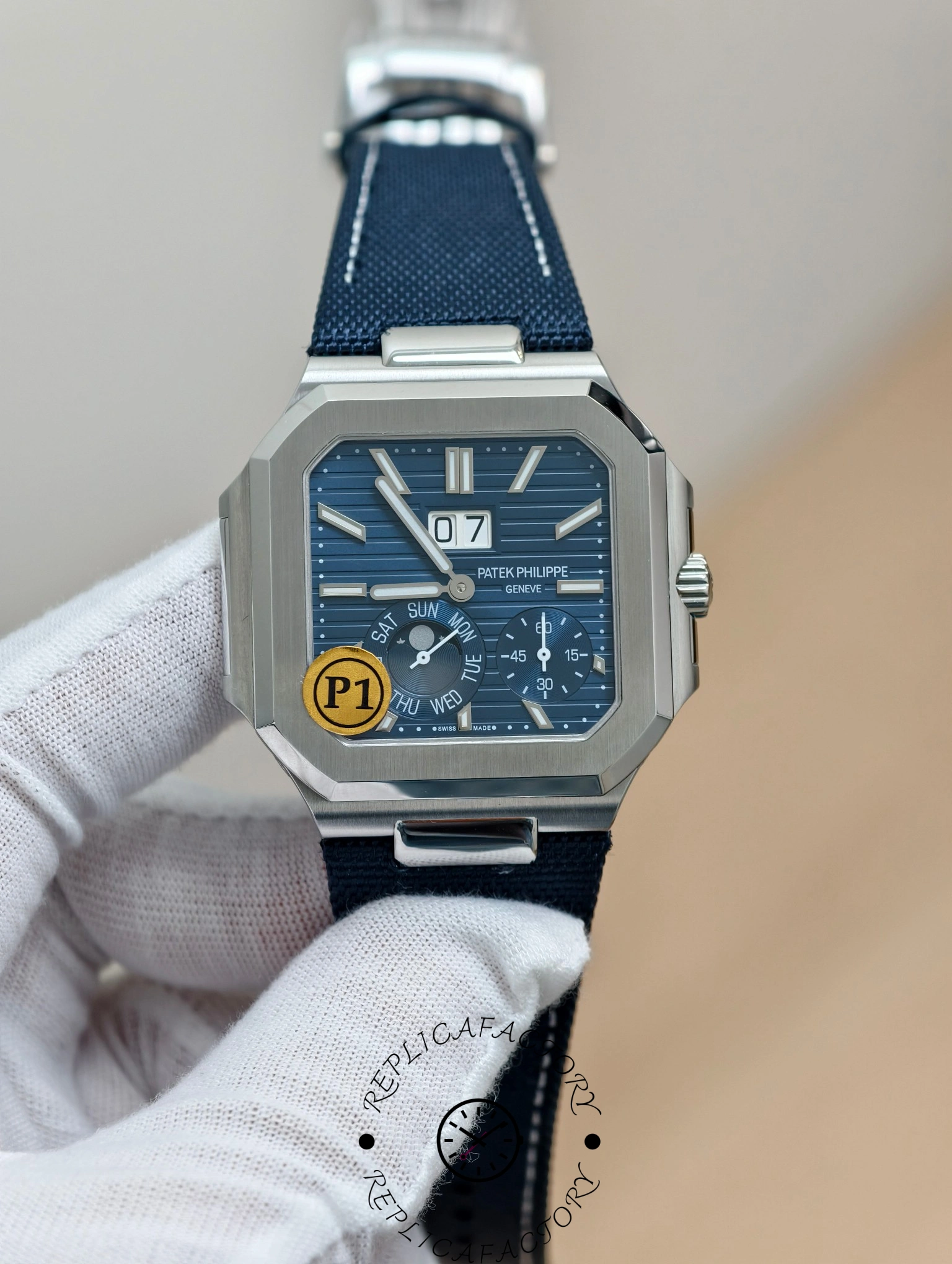 Patek Philippe Cubitus 5822P-001 in hand showing textured blue dial and large date window.
